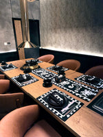 Dining table set with black and white placemats in a modern restaurant setting.
