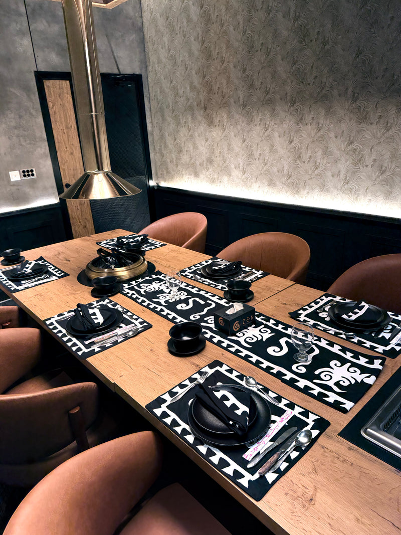 Dining table set with black and white placemats in a modern restaurant.