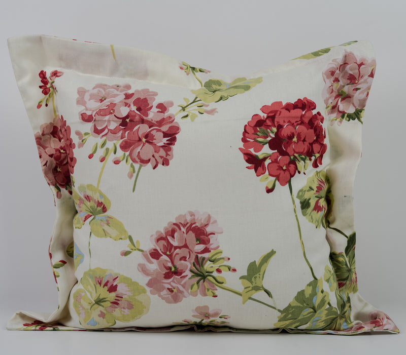 green, pink floral design on white cushion