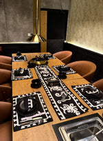 Dining table set for a meal with placemats and cutlery in a restaurant setting.
