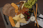 Wooden tray with fruits and cheese on it